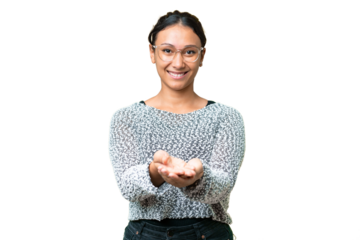 Young Uruguayan woman over isolated chroma key background holding copyspace imaginary on the palm to insert an ad