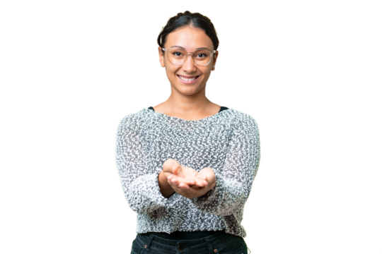 Young Uruguayan woman over isolated chroma key background holding copyspace imaginary on the palm to insert an ad