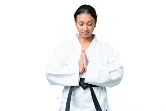 Young Uruguayan woman over isolated chroma key background doing karate and saluting