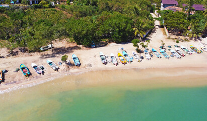 Aerial view of colorful fishing boats on the ocean. Beautiful Asian texture background for tourism and advertising. Tropical landscape from a drone