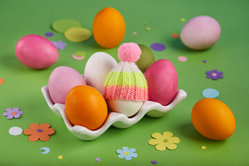 Fototapeta na wymiar Colored Easter eggs, one egg decorated with hat. Spring greeting card banner with traditional Easter symbols. 