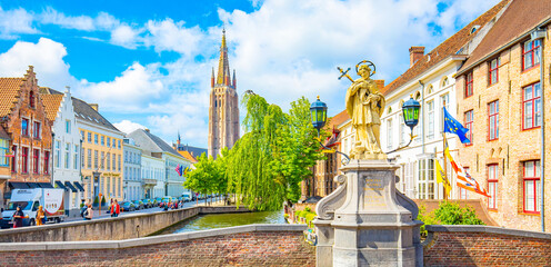 Scenic view of Bruges old town, statue of St John Nepomucene on Wollestraat bridge, Belgium