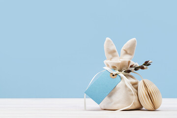 Easter bunny shaped Ivory gift bag with sweets and blue mockup gift tag and paper craft Easter egg...