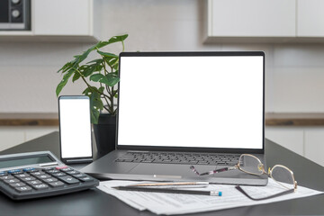 Fototapeta premium smartphone and laptop with blank screen, calculator on the table. copy space, mockup