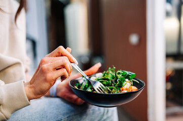 Woman's hands eat wegetables salad