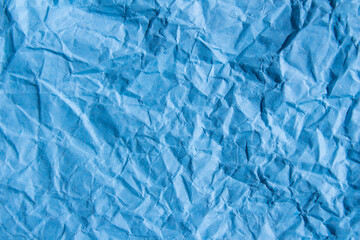 Crumpled blue paper texture background. Wrinkled paper surface for designs.