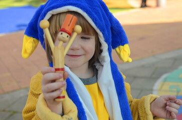 Jewish holiday Purim. A boy in a carnival costume with a grager in his hands.
