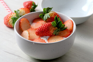 White bowl with yogurt and strawberries