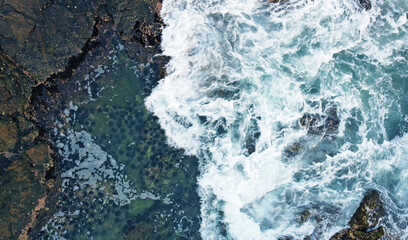 Aerial view of the sea rocks cliffs in the ocean. Beautiful sea wallpaper for tourism and advertising. Stormy landscape, drone photo