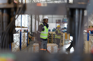 Worker in auto parts warehouse use a handcart to work to bring the box of auto parts into the...