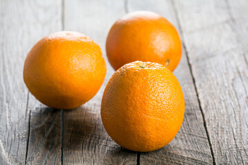 Ripe juicy oranges on a wooden surface