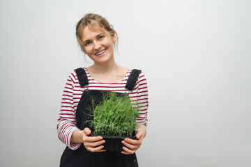 A woman is holding a micro green in her hands. Close-up.