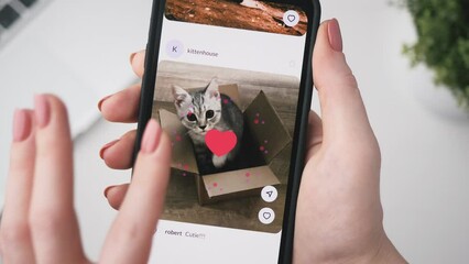 Woman scrolls through her social media feed and gives some photos a like. Image-Based Social Media Application for Mobile Phone. - Powered by Adobe