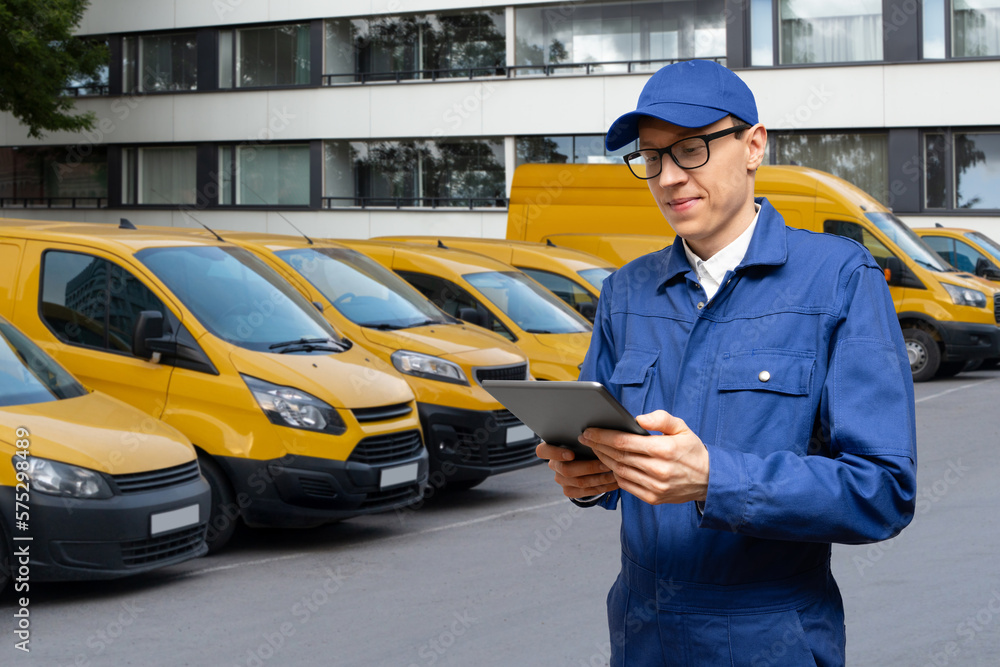 Poster Manager with a digital tablet on the background of vans. Fleet management	