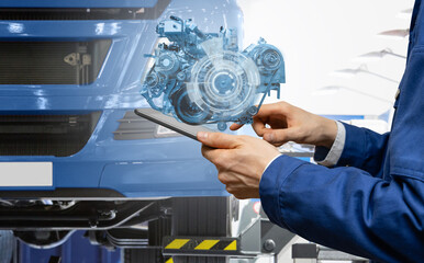 Serviceman repairing a truck using augmented reality application.	