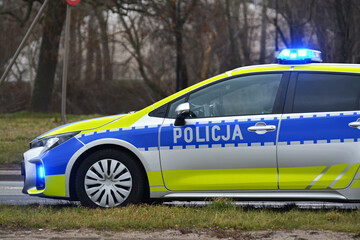 Radiowóz polskiej policji drogowej z policjantem, nowy  podczas służby w mieście. Nowe barwy. 