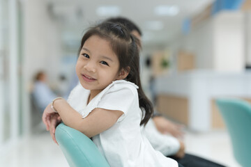 Girl sitting smiling in the hospital lobby.