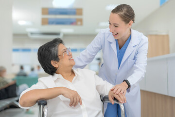 Doctor helping senior patient push wheelchair.