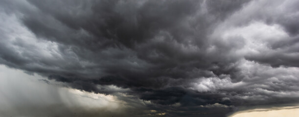 The dark sky with heavy clouds converging and a violent storm before the rain.Bad or moody weather sky and environment. carbon dioxide emissions, greenhouse effect, global warming, climate change