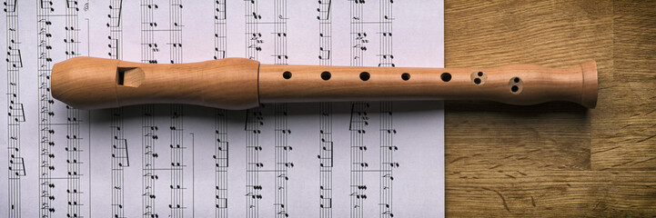 Das Musikinstrument Blockflöte liegt auf einem Notenblatt