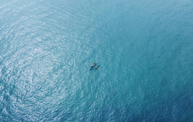 Aerial view of a fishing boat with fishermen in the blue ocean. Beautiful sea wallpaper for tourism and advertising. Asian landscape, drone photo