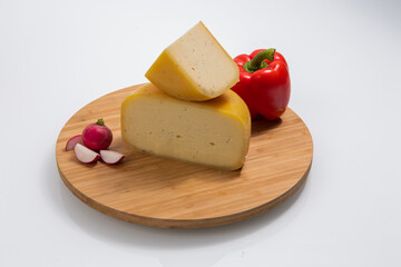 Bosnian traditional cheese served on a wooden container with peppers, parade and onions isolated on a white background
