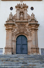 Fototapeta premium detail view of the ornate Baroque entrance and door of the Sanctuary of our Lady of the Holy Fountain in Murcia