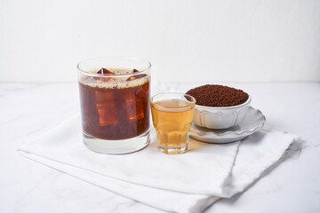 Popular cocktail called carajillo made with espresso, liquor and ice on white marble table