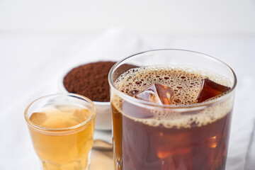 Carajillo, cocktail made of coffee, liquor and ice, on white marble table