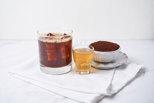Popular cocktail called carajillo made with espresso, liquor and ice on white marble table