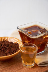 Carajillo, cocktail made of coffee, liquor and ice, on wooden board