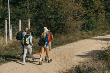 Four hikers walking on a dirt road
