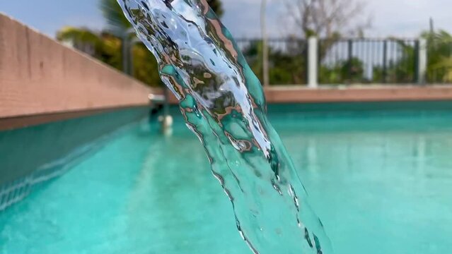 Filling the pool with artesian water flowing from the pipe. 