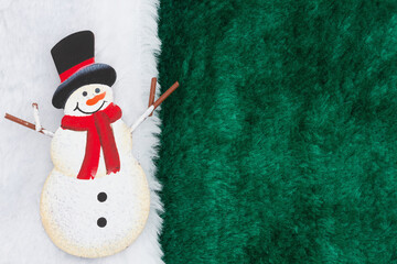 Fototapeta premium Snowman with green fleece material with white border