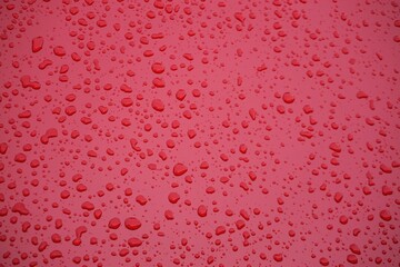 Rote Metallfläche mit Regentropfenmuster als Hintergrund