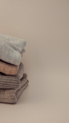 Stack of folded knitted sweaters close-up isolated on white background