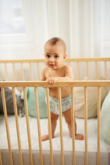 Portrait of a baby standing in the crib