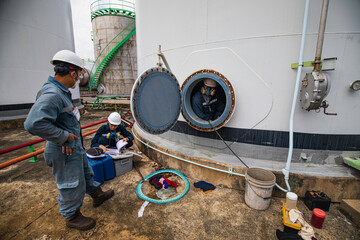 Male worker into the tank carbon chemical oil interface area confined space