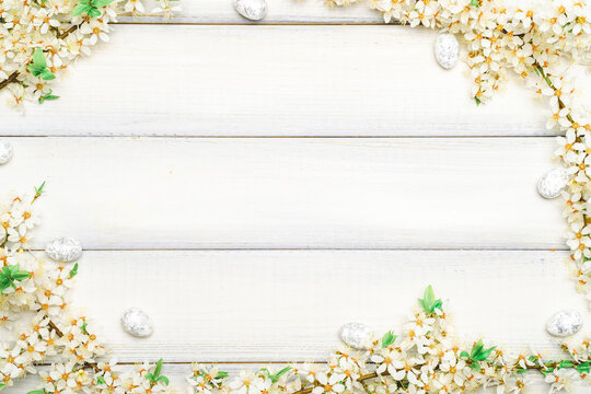 Easter flat. Cherry tree blossom, white happy easter eggs on wood spring background. Springtime concept.