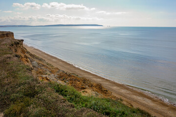 Coastal landscape viewed from top of cliff above beach. sea view with eroded cliffs