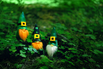 toy irish gnomes in mystery forest, abstract green natural background. magic friends dwarfs  and fantasy nature. fairy tale image. harmony beautiful spring or summer season. symbol of Ireland - obrazy, fototapety, plakaty