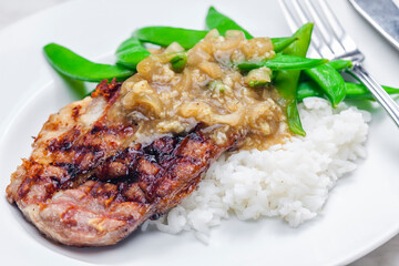 pork steak with onion sauce, green beans and rice