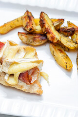 poultry meat grilled with parma ham and brie cheese served with roasted potatoes