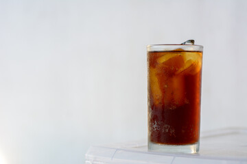 Cola in glass with ice cubes on white background.
