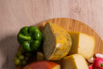Bosnian traditional cheese served on a wooden container with peppers, parade and onions isolated on a white background