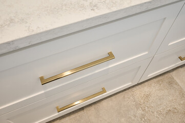 closeup angled view of cabinet drawers with gold hardware and stone countertop - 575340684