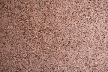 Red cement texture on wall with marked stones.