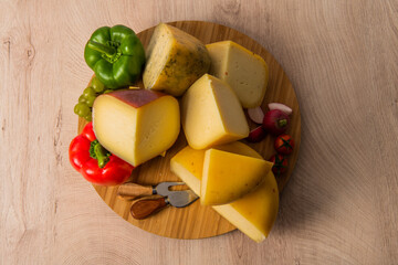 Bosnian traditional cheese served on a wooden container with peppers, parade and onions isolated on a white background