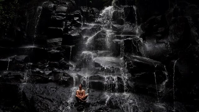 Young Man Relaxing In The Jungle Near Kanto Lampo Waterfall In Bali, Indonesia