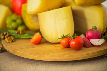 Bosnian traditional cheese served on a wooden container with peppers, parade and onions isolated on a white background